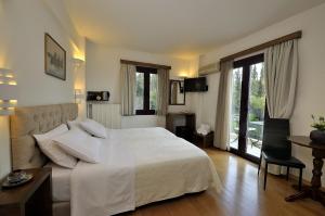 a bedroom with a large white bed and a couch at Dryades & Orion Hotel in Athens