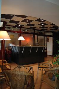 a bar in a restaurant with a checkerboard ceiling at Hôtel de Bourgogne in La Clayette