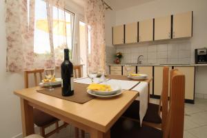 una cocina con una mesa con una botella de vino y copas en Apartments Nikolic, en Šilo
