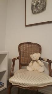um urso de peluche sentado numa cadeira num quarto em City Apartment Snellmaninkatu 22 B em Kuopio