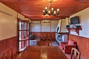 a dining room with a wooden table and a fireplace at Guest House Villa Teres in Shipka
