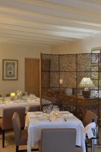 un comedor con mesas con manteles blancos en Logis Hotel Le Continental en Châteauroux