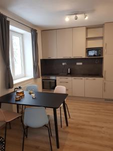 リプノ・ナト・ヴルタヴォウにあるSport Apartmentのキッチン(黒いテーブル、白い椅子付)