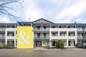 un edificio de oficinas con un cartel delante en B&B HOTEL Grenoble Université en Gières