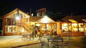 a restaurant with tables and chairs in front of a building at Hotel At The End Of The Universe in Nagarkot