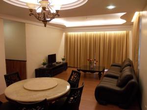 uma sala de estar com um sofá e uma mesa em Bali Style Apartment @ Imperial Court em Cameron Highlands