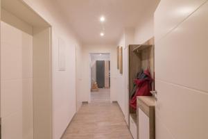 a hallway with white walls and a long hallway at Ferienwohnung Ulrike in Blieskastel