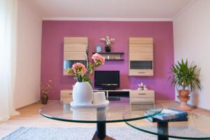 ein Wohnzimmer mit einem Glastisch und lila Wänden in der Unterkunft Ferienwohnung Ulrike in Blieskastel
