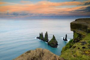 an island in the ocean with rocks in the water at Hótel Kría in Vík