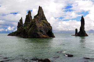 an island in the ocean with rocks in the water at Hótel Kría in Vík