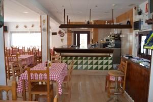 a kitchen and dining room with tables and chairs at Hostal Casa Torrent in Canet de Mar