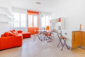 ボローニャにあるOrange Apartment Bolognaのリビングルーム(オレンジ色のソファ、テーブル付)