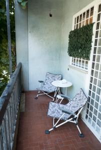 patio z 2 krzesłami i stołem na ganku w obiekcie Next Stop Roma Affittacamere Da Florindo w Rzymie