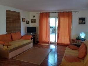 a living room with a couch and a tv at A Due Passi Dal Mare Con Piscina in Fontane Bianche
