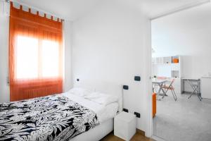 a bedroom with a bed and a window and a table at Orange Apartment Bologna in Bologna