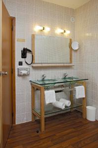 a bathroom with a sink and a mirror at Hôtel Tour Maje in Rodez