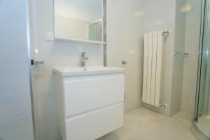 biała łazienka z umywalką i prysznicem w obiekcie Apartment Aldo II w Poreču +12 zdjęć