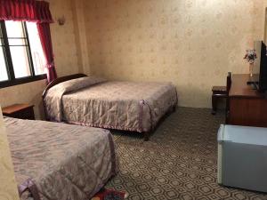 Una habitación de hotel con dos camas y un televisor. en Thaveesinh Hotel, en Ban Houayxay 23 fotos más