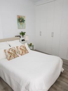セビリアにあるCasa Aguilasのベッドルーム1室(白いベッド1台、枕2つ付)