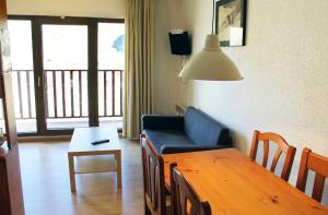 a living room with a table and a blue couch at Apartamentos Paradis Blanc 3000 in Pas de la Casa
