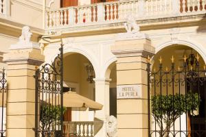 un edificio con una puerta de hierro forjado delante en Hotel la Perla Leon, en León