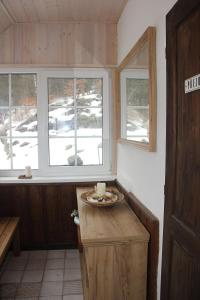 una cocina con 2 ventanas y una mesa con una vela en Chata Fajfrtka, en Janov nad Nisou