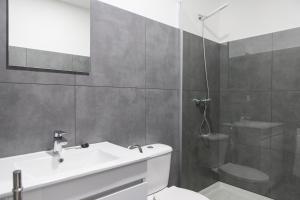 a bathroom with a sink and a toilet and a shower at Porto Republica Hostel & Suites in Porto