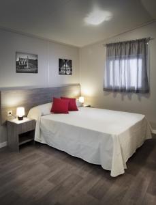 1 dormitorio con 1 cama blanca grande con almohadas rojas en Lg Residenz, en Crevillente