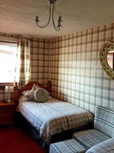 a bedroom with a bed and a window and a chair at Rooms at Tarrareoch in Bathgate