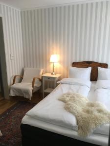 a bedroom with two beds and a table with a lamp at Sogndalstrand Kulturhotell in Sogndalsstrand