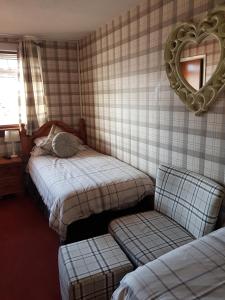 a bedroom with two beds and a mirror on the wall at Rooms at Tarrareoch in Bathgate