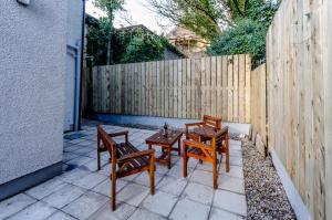 a patio with three chairs and a table and a fence at fairhill holiday let in Ballycastle