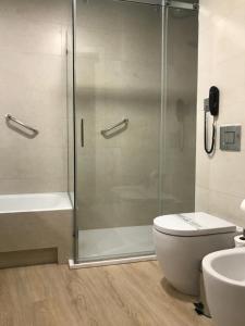 a bathroom with a shower, toilet, and sink at Hotel América Sevilla in Seville