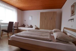 a bedroom with two beds and a table and a desk at Haus Gisela - Self Check-in - Jakobsweg - Etappe von Höxter bis Brakel in Brakel
