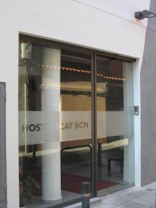 Una ventana de cristal de un edificio con un cartel que lee el apartamento secreto Ben en Hostelscat, en Barcelona