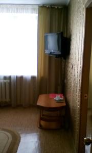a room with a table and a television on a wall at Hotel Belebey in Belebey