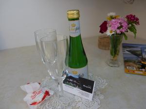 eine Flasche Wein und zwei Gläser auf dem Tisch in der Unterkunft Gästehaus Margareta in Wald im Pinzgau