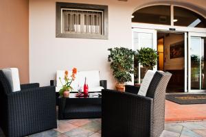 a patio with wicker chairs and a table at Hotel La Campagnola in Fucecchio
