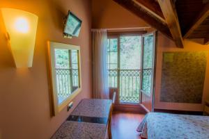 a bedroom with two beds and two windows at Adeko Hotel in Barakaldo