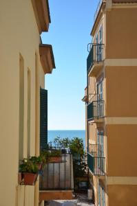 un callejón entre dos edificios con el océano en el fondo en Holidayhouse Ostia - Maestrale, en Lido di Ostia 2 fotos más