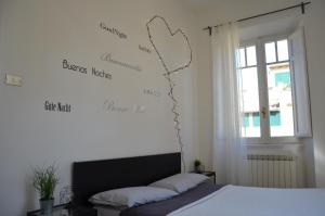 ein Schlafzimmer mit einem Bett und einer Wand mit Worten drauf in der Unterkunft Holidayhouse Ostia - Maestrale in Lido di Ostia