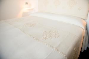 a white bed with a white blanket on it at Faro Capo Spartivento in Chia