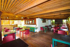 a restaurant with many tables and chairs and wooden ceilings at Takamaka Green Village in Takamaka