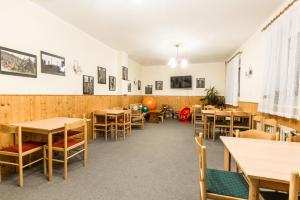 comedor con mesas y sillas de madera en Hotel Gradl en Železná Ruda