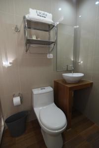 a bathroom with a white toilet and a sink at Hotel Escala in Chiclayo