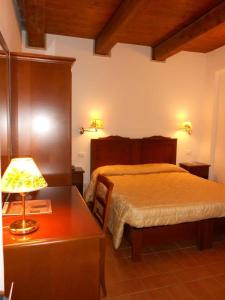 sypialnia z łóżkiem i stołem z lampką w obiekcie Hotel La Foresteria w mieście Abbadia di Fiastra