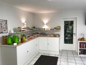 a kitchen with white cabinets and green appliances at Hotel Oelberg budget - BONN SÜD Königswinter in Königswinter