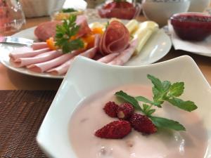 un plato de comida con fresas y carne en una mesa en Gästehaus Margareta, en Wald im Pinzgau
