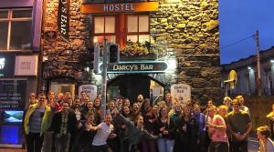 Galway City Hostel في غالواي: مجموعة أشخاص واقفين أمام مبنى