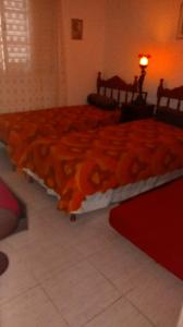 a bedroom with two beds and a red blanket at Meu Cantinho da Paz Em Águas de Lindóia in Águas de Lindoia